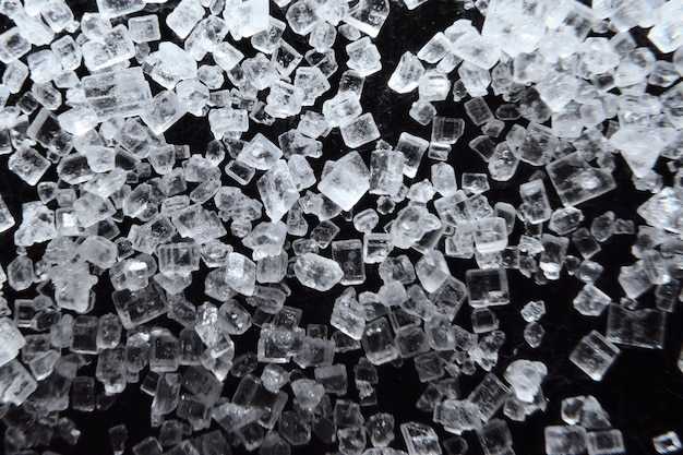 Zuckermakro. Zuckerkristalle schließen oben auf einem schwarzen Hintergrund.