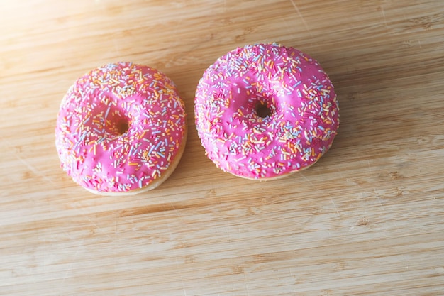 Zuckersucht Nahaufnahme eines mit Zucker bestreuten rosa Donuts