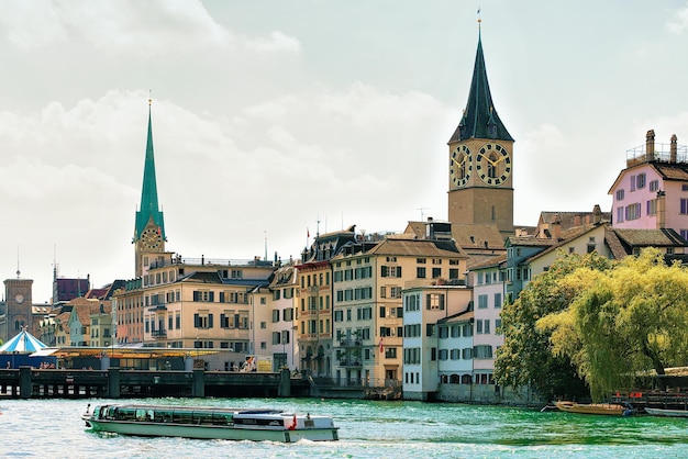 Zürich, Schweiz - 2. September 2016: Flusskreuzer am Limmatkai und St. Peter Kirche und Fraumünster Kirche im Stadtzentrum von Zürich, Schweiz.