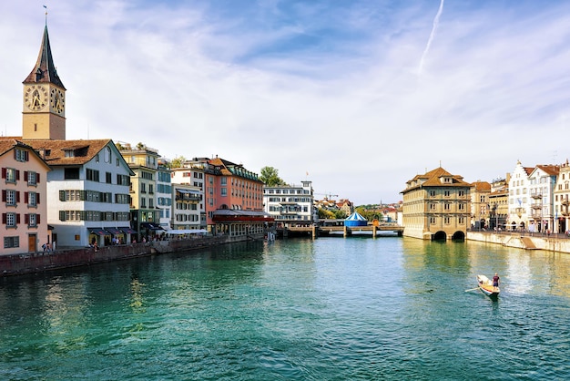 Zürich, Schweiz - 2. September 2016: Mann in einem Boot am Kai der Limmat und St. Peter Kirche im Stadtzentrum von Zürich, Schweiz