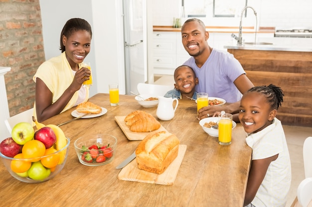 Zufällige glückliche Familie, die frühstückt