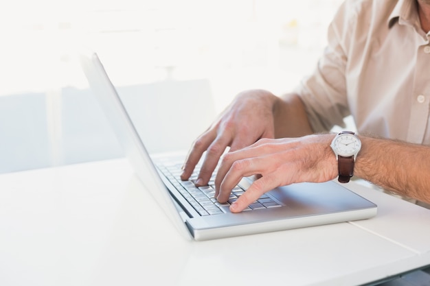 Zufälliger Geschäftsmann, der seinen Laptop verwendet