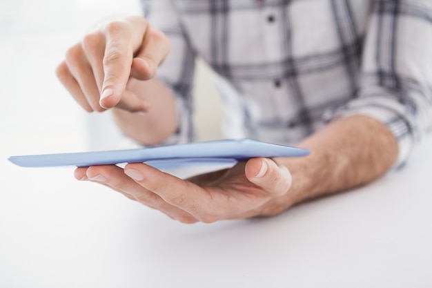 Zufälliger Geschäftsmann unter Verwendung der Tablette am Schreibtisch