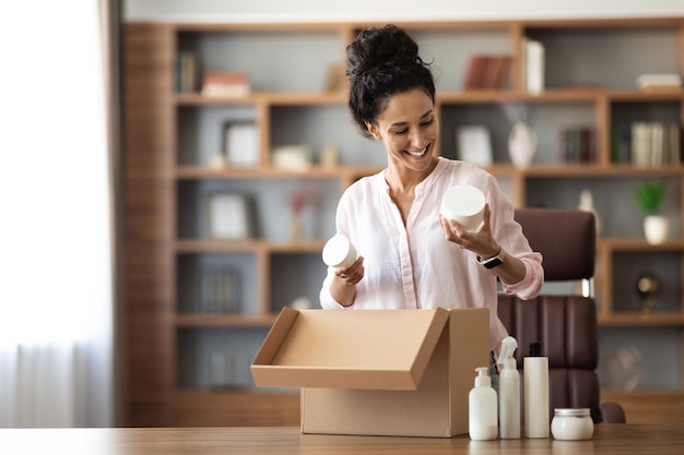 Zufriedene junge Kundin, die ihr Paket mit Kosmetik überprüft