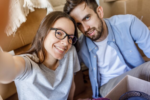 Zufriedenes Paar, das Selfie beim Packen nimmt