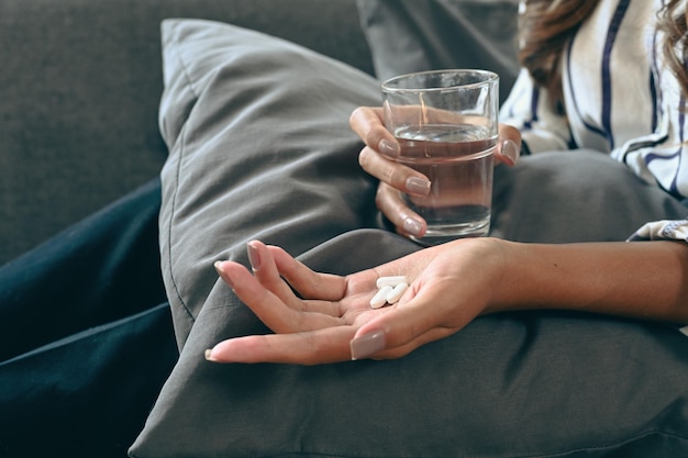 Zugeschnittene Schuss Frau mit einem Glas Wasser und Pillen Gesundheitskonzept