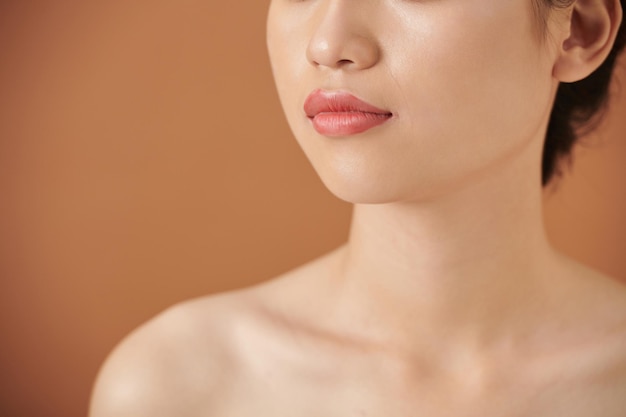 Zugeschnittenes Bild einer jungen Frau mit schöner, makelloser Haut und vollen Lippen