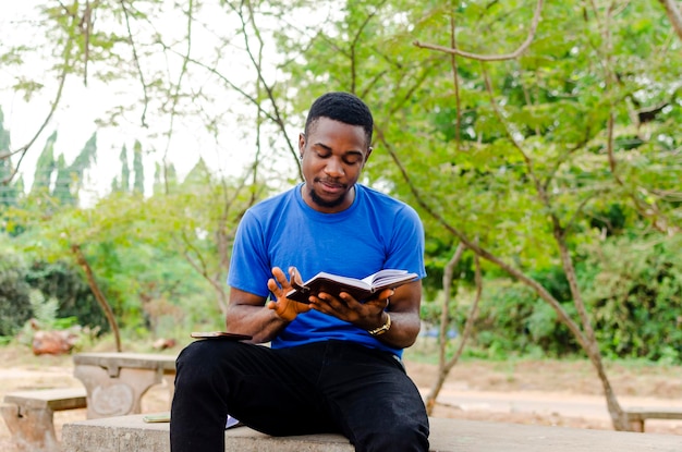 Zugeschnittenes Bild eines jungen afrikanischen Schülers, der ein Buch liest
