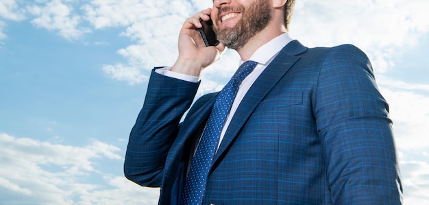 Zugeschnittenes Foto eines Mannes beim Telefonieren. Mann beim Telefonieren vor dem Hintergrund des Himmels