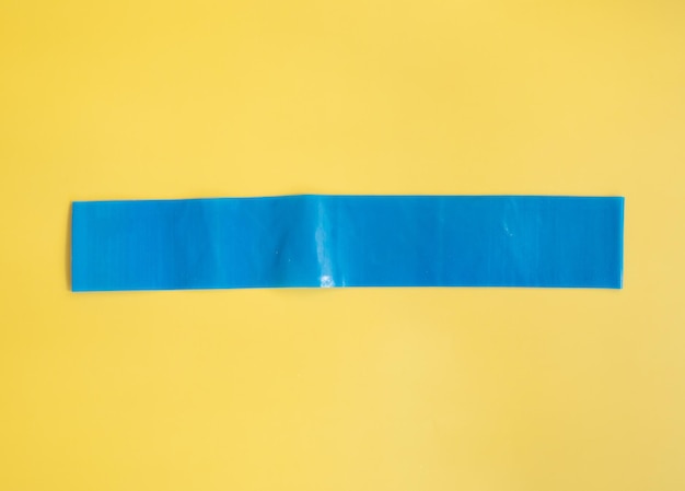 Zuhause-Trainingskonzept elastische Bänder auf gelbem Hintergrund flach legen
