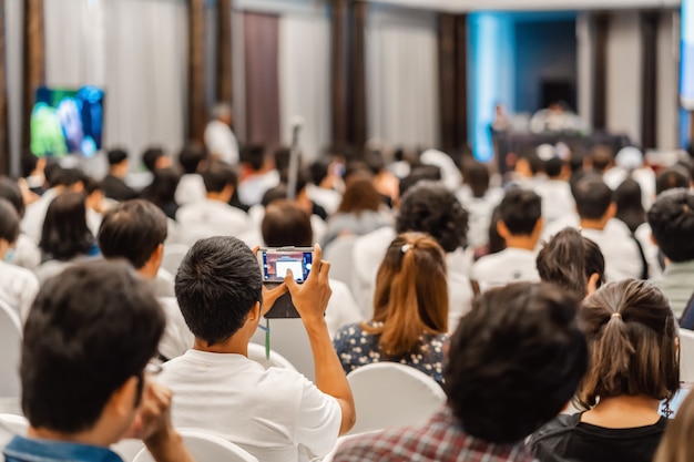 Zuhörer Lautsprecher und Mobiltelefon, die das Foto im Konferenzsaal aufnehmen