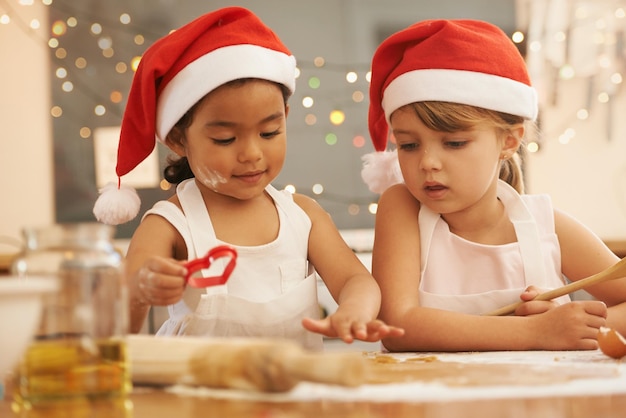 Zukünftige Bäckerinnen Zwei kleine Mädchen backen gemeinsam in der Küche