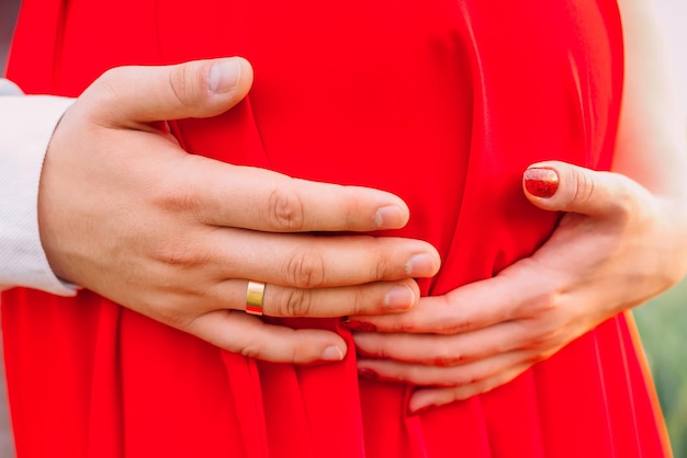 Zukünftige Eltern berühren den Bauch. Ein Paar legte der schwangeren Frau die Hände auf