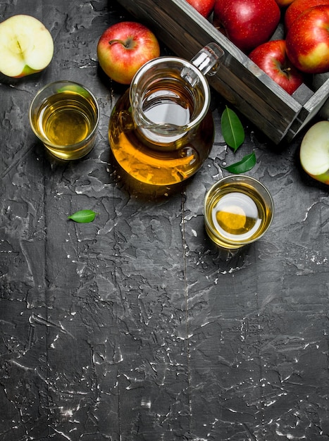 Zumo de manzana en un tarro de cristal con manzanas frescas en una caja