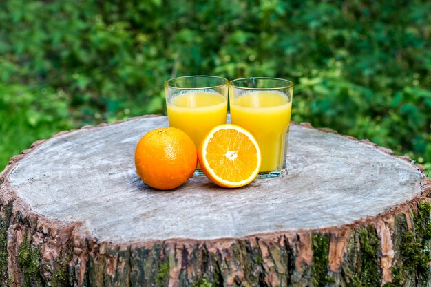 Zumo de naranja con frutas naranjas al aire libre