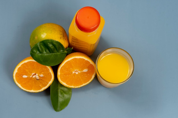 Zumo de naranja natural en el vaso con botella al lado