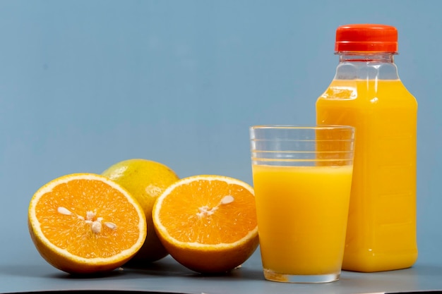 Zumo de naranja natural en el vaso con botella al lado
