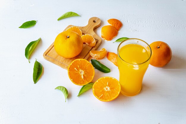Zumo de naranja recién exprimido y fruta de naranja cortada por la mitad