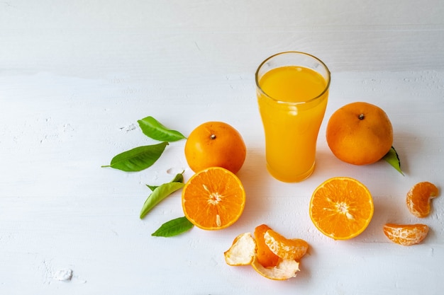 Zumo de naranja recién exprimido y fruta de naranja cortada por la mitad