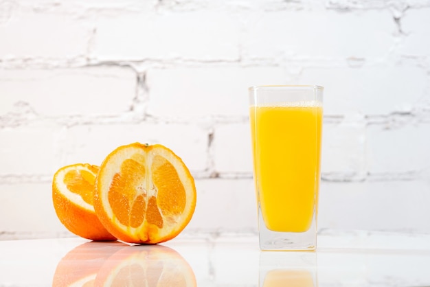 Zumo de naranja recién exprimido en un vaso sobre una mesa.