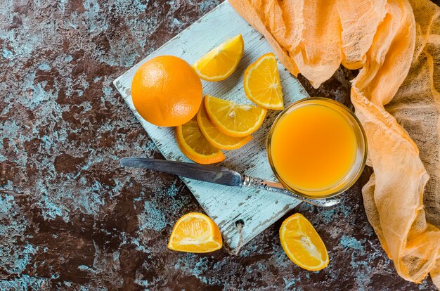 Foto zumo de naranja en vaso y trozos.