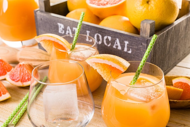 Zumo de pomelo rojo rubí ecológico en vaso pequeño con hielo.