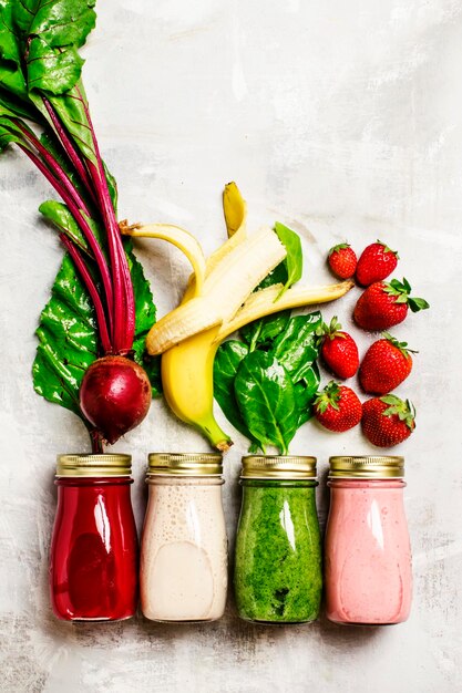 Zumos multicolores y batidos de verduras frescas frutas y bayas vista superior fondo de alimentos