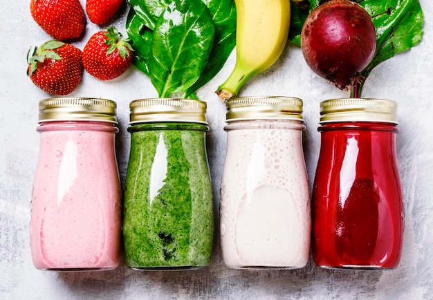 Zumos multicolores y batidos de verduras frescas frutas y bayas vista superior fondo de alimentos