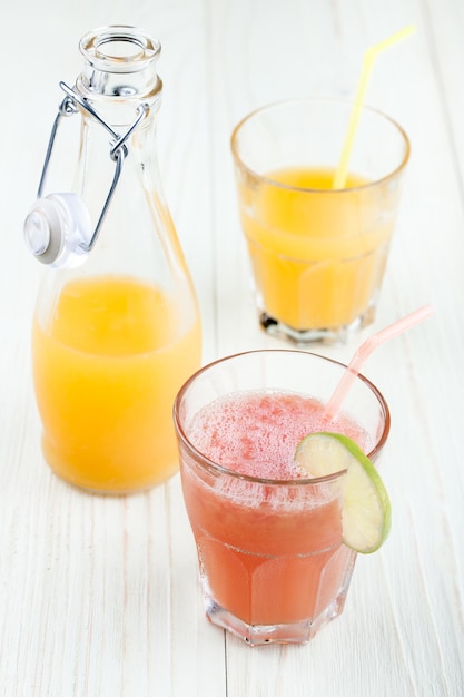 Zumos de pomelo y naranja en los vasos y en la botella.