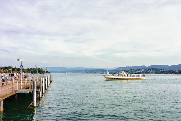 Zurich, Suiza - 2 de septiembre de 2016: Ferry y gente en el muelle del lago de Zurich, Suiza