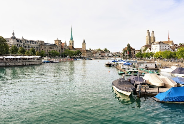 Zurich, Suiza - 2 de septiembre de 2016: Limmat River Quay con barcos y tres iglesias principales de Zurich - Grossmunster, Fraumunster y St Peter Church. Suiza