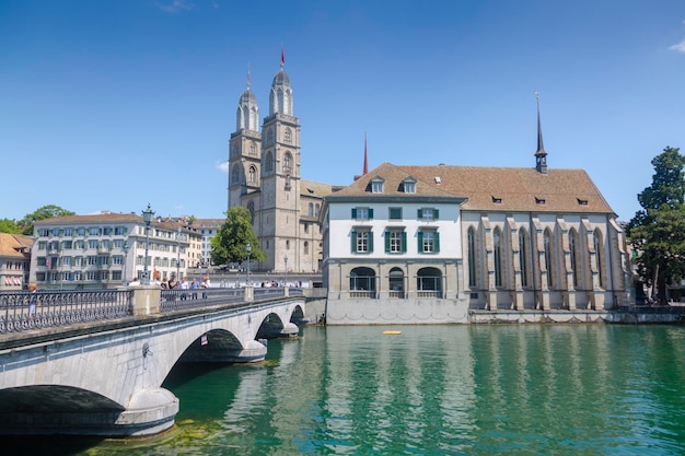 Zurique suíça 1 de agosto de 2019 panorama do centro histórico da cidade de zurique com a igreja fraumunster e munsterbucke atravessando o rio limmat