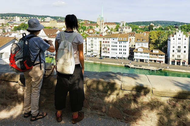 Zurique, suíça - 2 de setembro de 2016: dois mochileiros turistas femininos olhando para limmatquai, zurique, suíça.