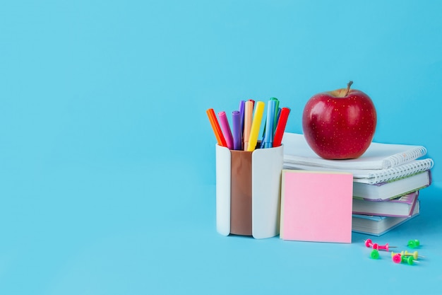 Zurück in der schule arbeit, arbeitsplatz eines schulkindbriefpapiers, notizbücher auf blau