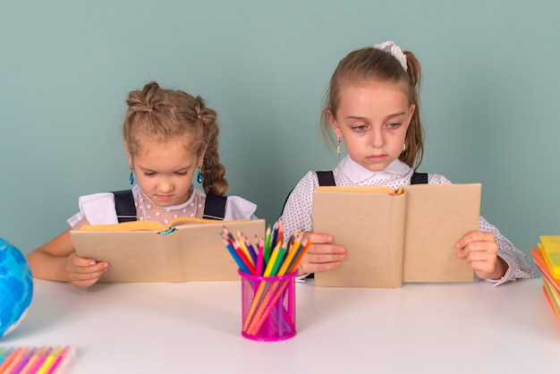 Zurück in der Schule schreiben Schulmädchen Zeichnen in ein Notizbuch, das am Tisch sitzt und Hausaufgaben machen