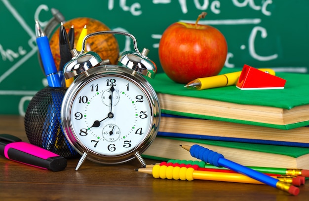 Zurück in die Schule - Tafel mit Bleistiftbox und Schulausrüstung auf dem Tisch