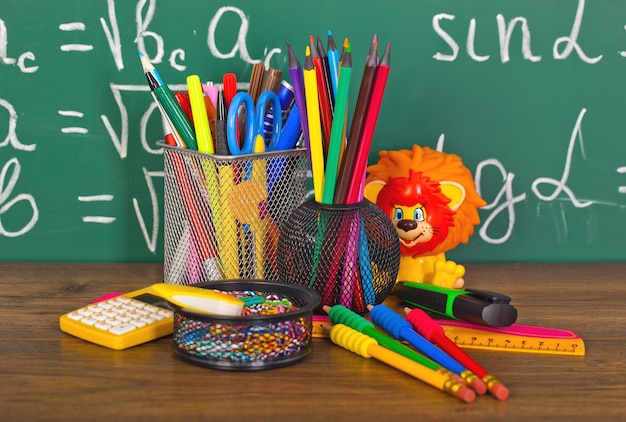 Zurück in die Schule - Tafel mit Bleistiftbox und Schulausrüstung auf dem Tisch