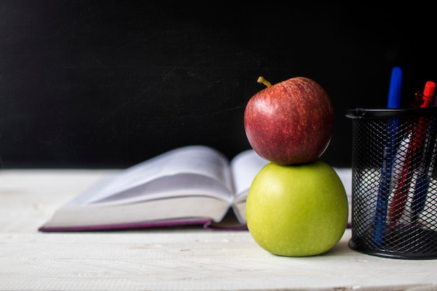 Zurück zu Schul-, Bildungs- und Wissenskonzept, Apfel und Anmerkungsbuch auf Tafelfronttafel