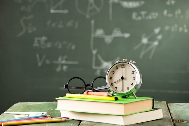 Zurück zu Schulhintergrund mit Büchern und Wecker über Tafel. Zurück zum Schulkonzept