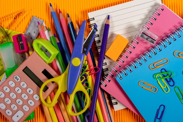 Zurück zu Schulkonzept. Notebook und Bildung Ausrüstung auf orange Hintergrund.