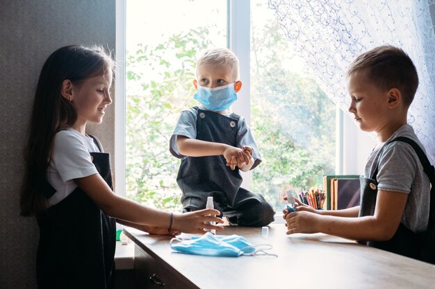 Zurück zu Schulsicherheitsschulkindern, die Masken tragen und Antiseptika im Klassenzimmer bei Schulkindern verwenden