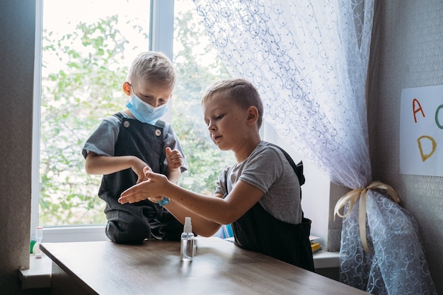 Zurück zu Schulsicherheitsschulkindern, die Masken tragen und Antiseptika im Klassenzimmer bei Schulkindern verwenden