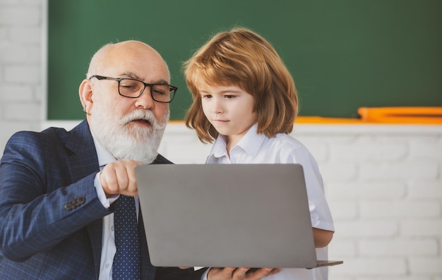 Zurück zum Schullehrer und Kind mit Laptop Online-Bildung und Lernkonzept Schüler in Klasse