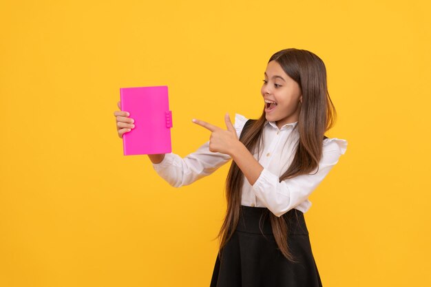 Zurück zur Schulbildung Buchladen Kinderleser Bildungsliteratur Bücherwurm Kind im Gymnasium Kopie Raum Werbung glückliches jugendlich Mädchen, das mit dem Finger zeigt, Buch-Nerd mit Planer-Notizblock