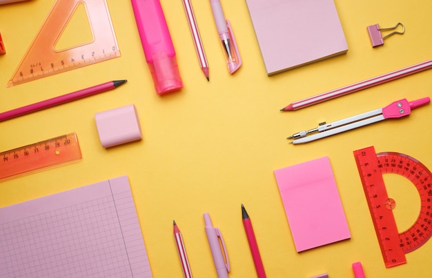 Zurück zur Schule. Gelber Hintergrund mit Schulmaterial: Aufkleber, Scheren, Marker, Globus, Lineale. Platz kopieren. Heller farbiger Hintergrund.