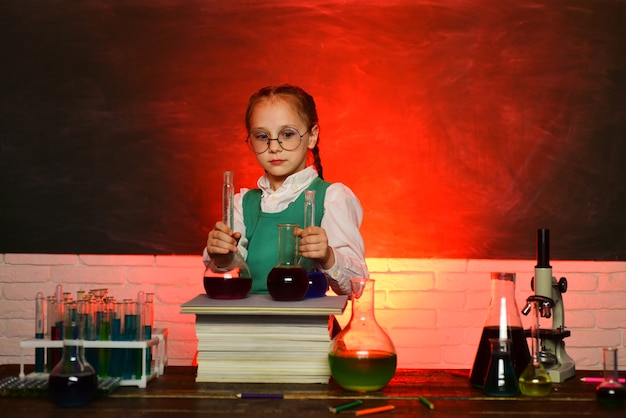 Zurück zur Schule. Kind aus der Grundschule. Kind im Klassenzimmer mit Tafel im Hintergrund. Mein Chemie-Experiment. Eine Chemiedemonstration.