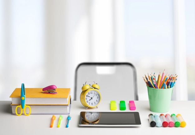 Zurück zur Schule. Kinderzimmer mit Holzschreibtisch, Büchern, Globus, Rucksack, Brille und Bleistiften.