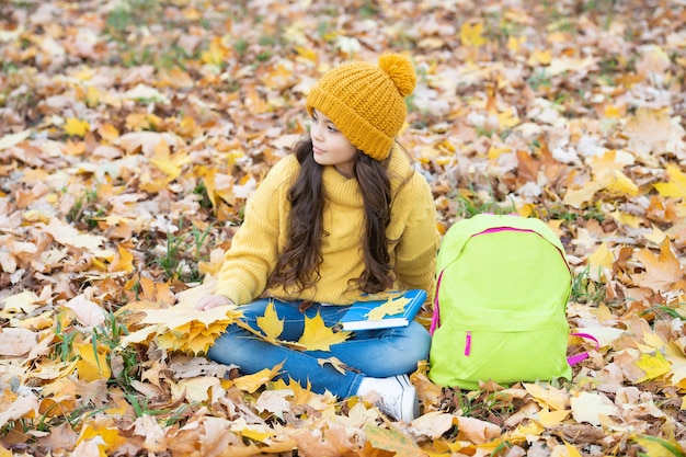 Zurück zur Schule. natürliche Schönheit. Mode für die Herbstsaison. Teenager-Mädchen im Hut halten Herbstblatt. Kind entspannen sich mit gelbem Ahornblatt und Rucksack im Freien. Herbst Natur.