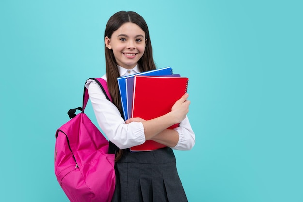 Zurück zur Schule Schulmädchen mit Schultaschenrucksack halten Buch auf isoliertem Studiohintergrund