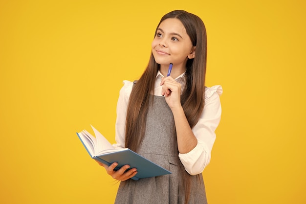 Zurück zur Schule Teenager-Schülerin mit Buch bereit zu lernen Schulmädchenkinder auf isoliertem gelbem Studiohintergrund Denkendes Teenager-Mädchen nachdenkliche Emotion
